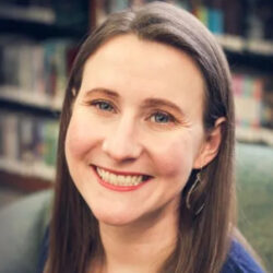 Smiling woman with long brown hair in a library setting. Smiling woman with long brown hair in a library setting.
